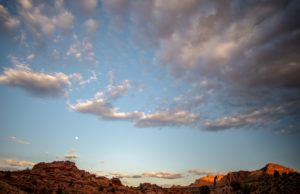 A view of a partly cloudy sky, with mountains on the horizon.